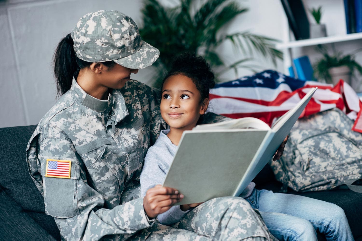 Featured image for VA Education Benefits for Dependents and Survivors, showing a female soldier with her daughter reading together in their home